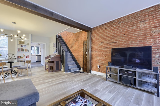 living area featuring a chandelier, stairway, wood finished floors, and beam ceiling