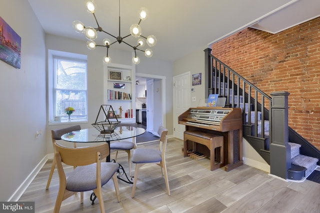 dining area featuring brick wall, stairway, wood finished floors, and baseboards