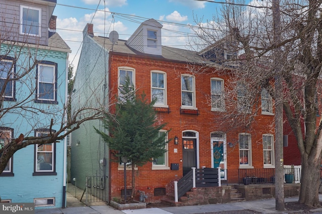 view of property featuring brick siding and fence