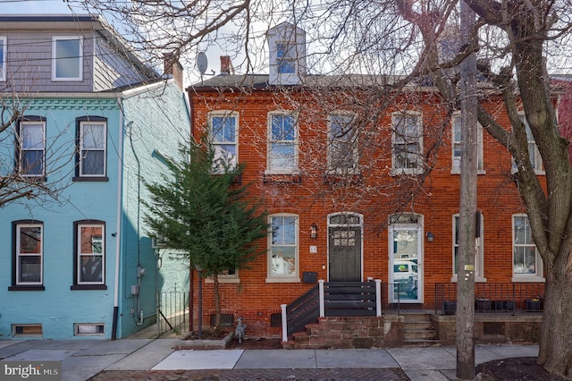 townhome / multi-family property featuring brick siding and a chimney