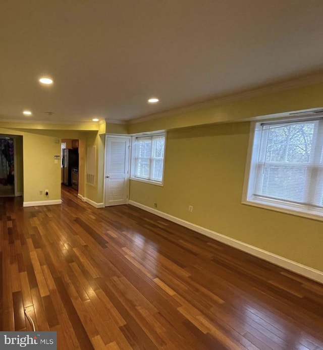 unfurnished living room with crown molding and dark hardwood / wood-style flooring