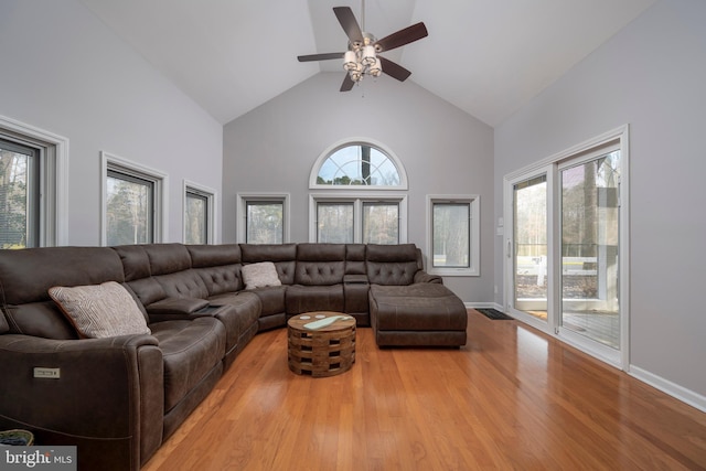 living room with ceiling fan, high vaulted ceiling, and light hardwood / wood-style flooring