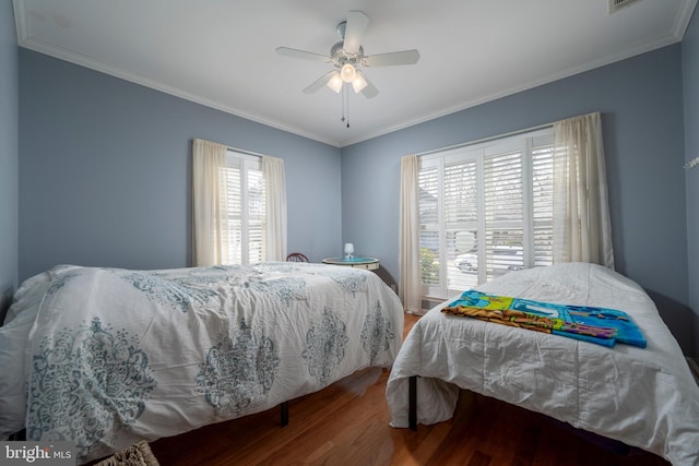 bedroom with hardwood / wood-style flooring, ceiling fan, and ornamental molding