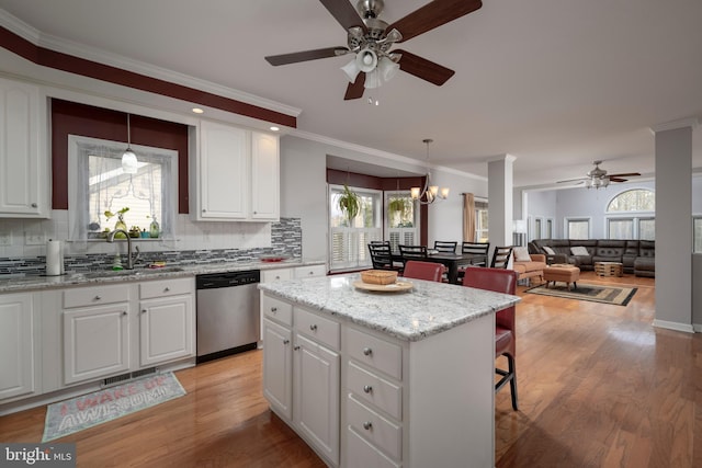 kitchen featuring sink, stainless steel dishwasher, white cabinets, and a kitchen island