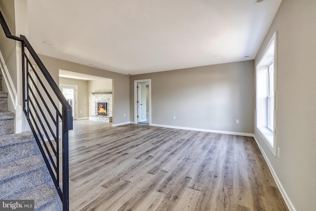 unfurnished living room featuring a fireplace and light hardwood / wood-style flooring