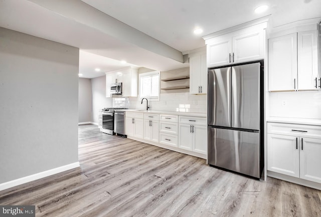 kitchen featuring tasteful backsplash, white cabinets, and appliances with stainless steel finishes