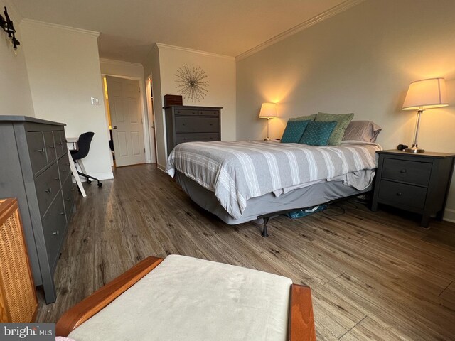 bedroom featuring baseboards, ornamental molding, and wood finished floors