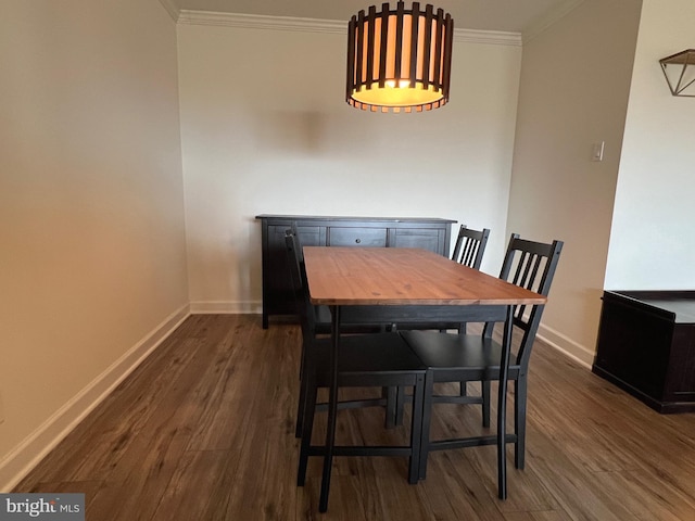 dining area featuring baseboards, dark wood-type flooring, and crown molding