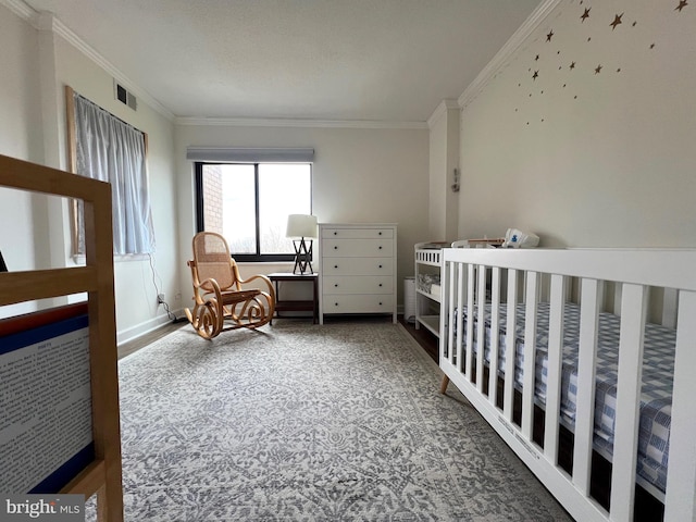 bedroom featuring a crib, carpet, visible vents, and ornamental molding