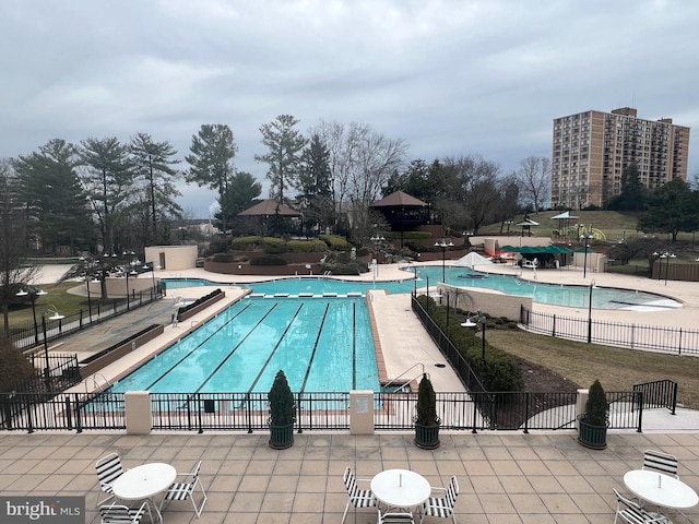 pool with a patio and fence