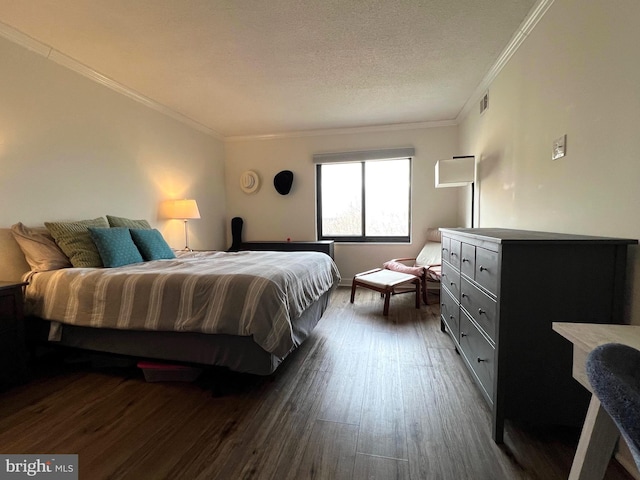 bedroom featuring dark wood-style floors, ornamental molding, a textured ceiling, and visible vents