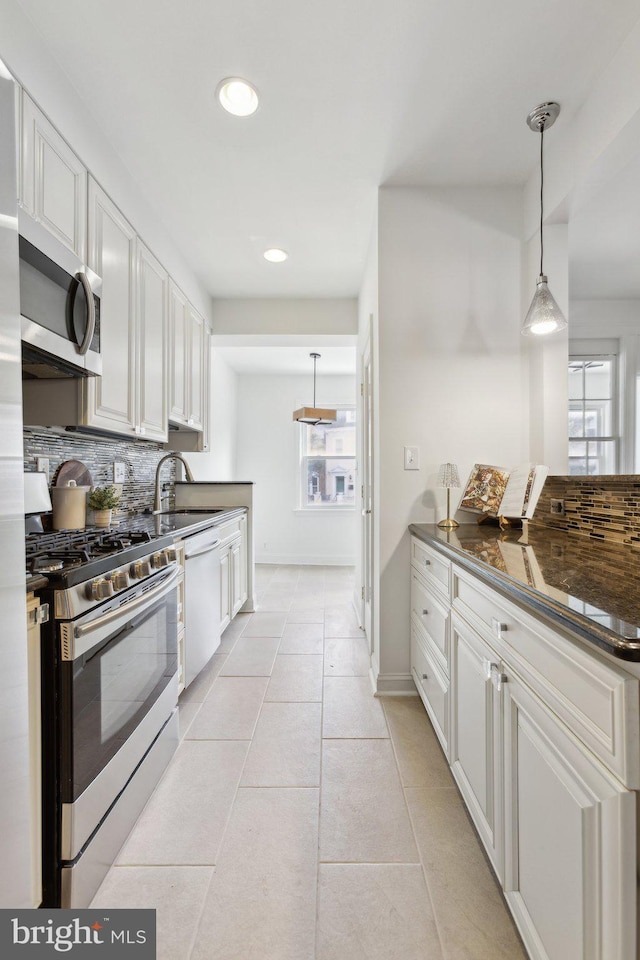 kitchen featuring sink, decorative light fixtures, stainless steel appliances, and white cabinets