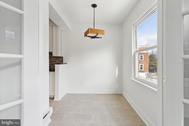 unfurnished dining area featuring a healthy amount of sunlight and light tile patterned flooring