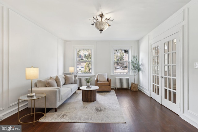 living room featuring dark wood-type flooring and radiator heating unit