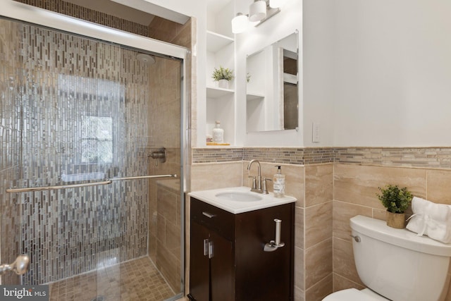 bathroom with walk in shower, vanity, toilet, and tile walls