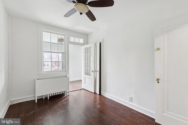 empty room featuring radiator, dark hardwood / wood-style floors, and ceiling fan