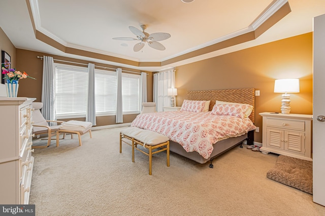 carpeted bedroom with crown molding, ceiling fan, and a raised ceiling