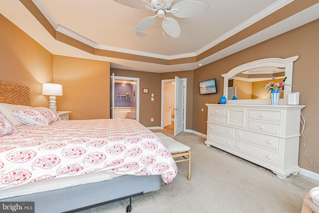 carpeted bedroom with a tray ceiling, connected bathroom, crown molding, and ceiling fan