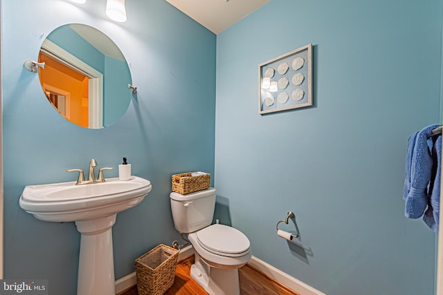 bathroom with wood-type flooring, toilet, and sink