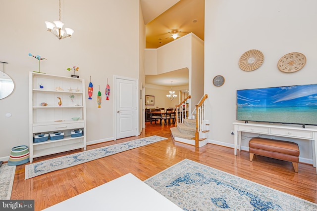 entryway with a high ceiling, hardwood / wood-style flooring, and an inviting chandelier