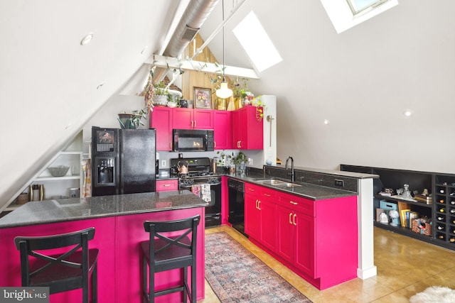 kitchen featuring a kitchen island, a breakfast bar, black appliances, sink, and kitchen peninsula