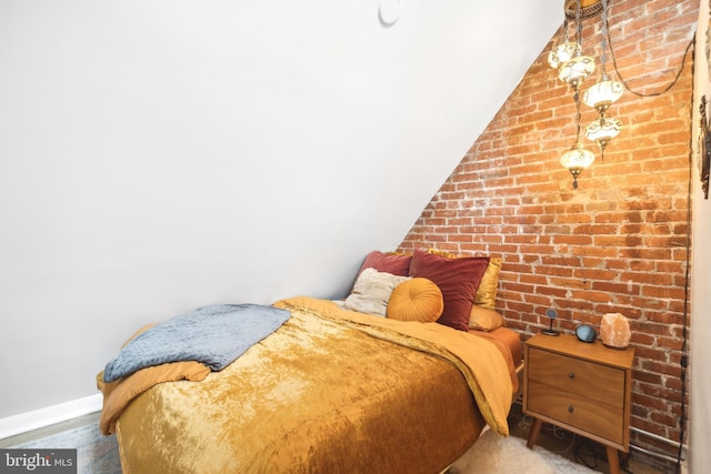 bedroom with brick wall and vaulted ceiling