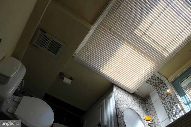 bathroom with toilet and visible vents