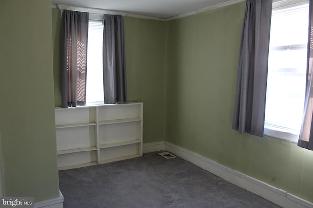 carpeted spare room with visible vents and baseboards