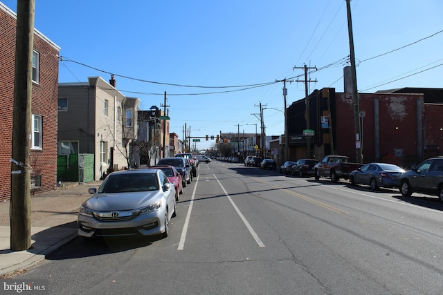 view of road featuring curbs, traffic lights, and sidewalks