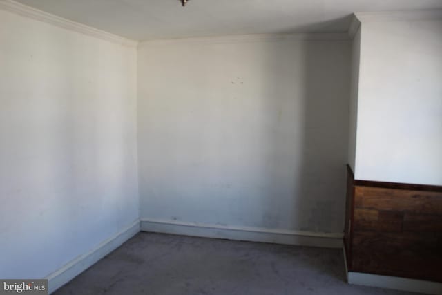 empty room featuring baseboards and ornamental molding