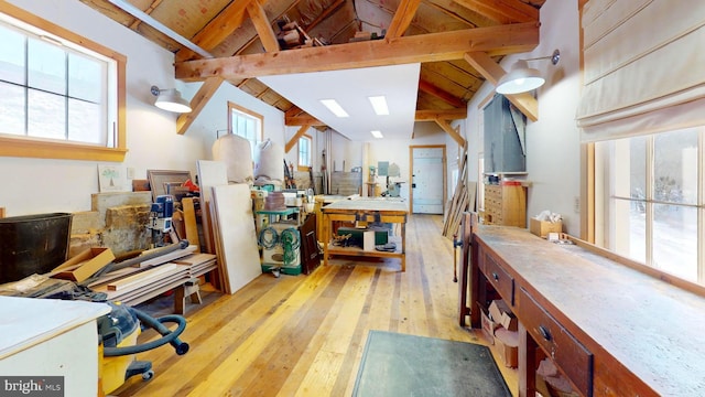 kitchen with beam ceiling, high vaulted ceiling, and light wood-type flooring