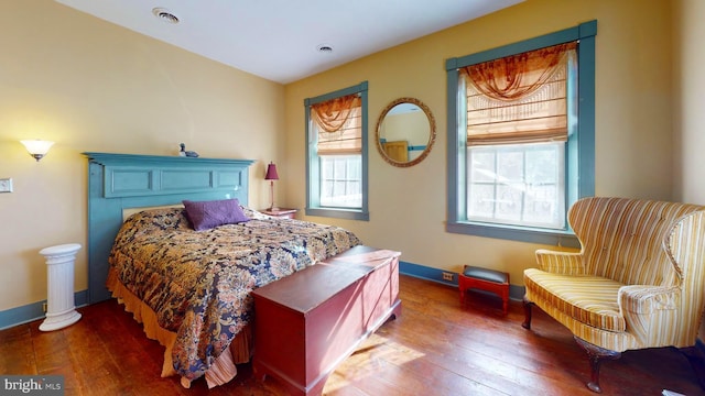 bedroom with wood-type flooring and multiple windows