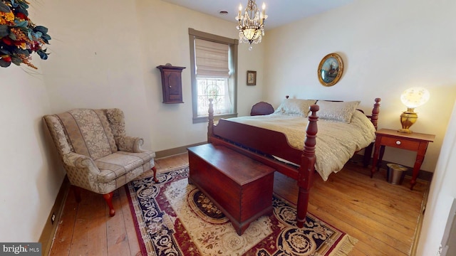 bedroom with a notable chandelier and light wood-type flooring