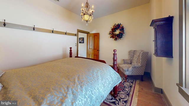 bedroom with hardwood / wood-style flooring and a chandelier