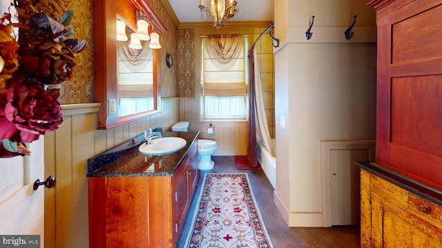 full bathroom with a notable chandelier, vanity, shower / tub combo with curtain, and toilet