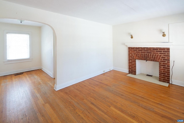 unfurnished living room featuring a fireplace and light wood-type flooring