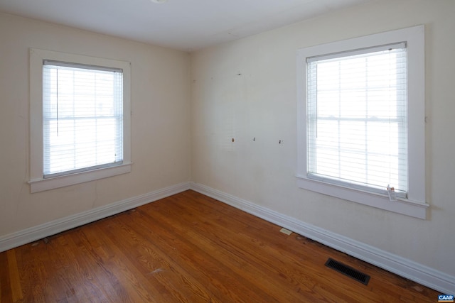 spare room featuring hardwood / wood-style flooring and plenty of natural light