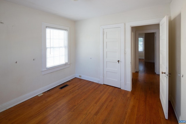 spare room featuring plenty of natural light and dark hardwood / wood-style floors