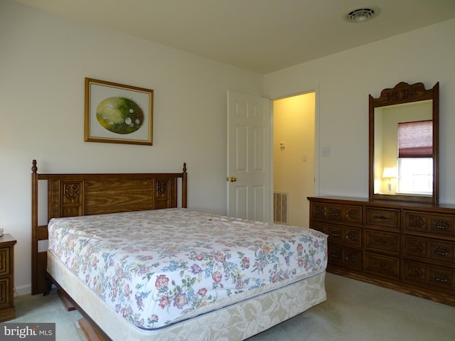 bedroom featuring visible vents and light colored carpet