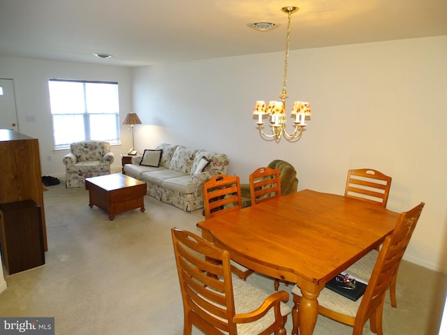 dining room featuring light colored carpet and an inviting chandelier