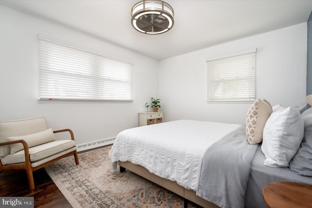 bedroom with multiple windows, a baseboard radiator, and dark hardwood / wood-style floors