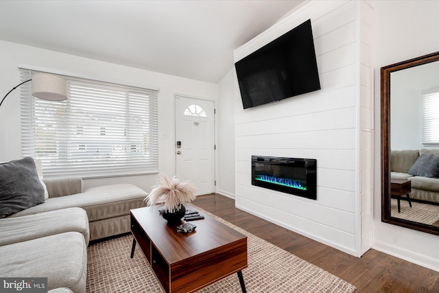 living room featuring lofted ceiling, dark hardwood / wood-style floors, and a fireplace