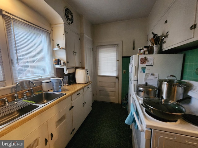 kitchen featuring white cabinetry, sink, tasteful backsplash, and range with electric stovetop