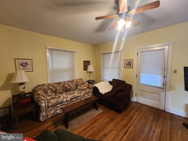 living room with dark hardwood / wood-style flooring and ceiling fan