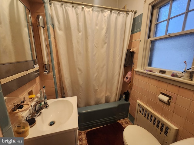 full bathroom with shower / bathtub combination with curtain, radiator, tile walls, vanity, and toilet