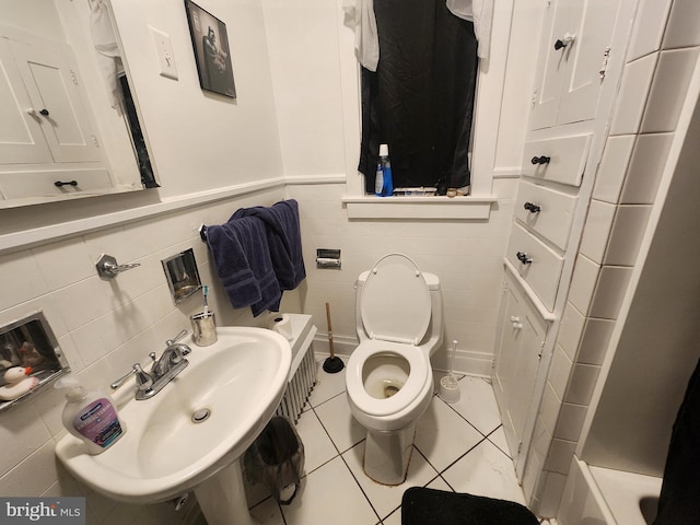 bathroom with sink, tile walls, tile patterned floors, and toilet