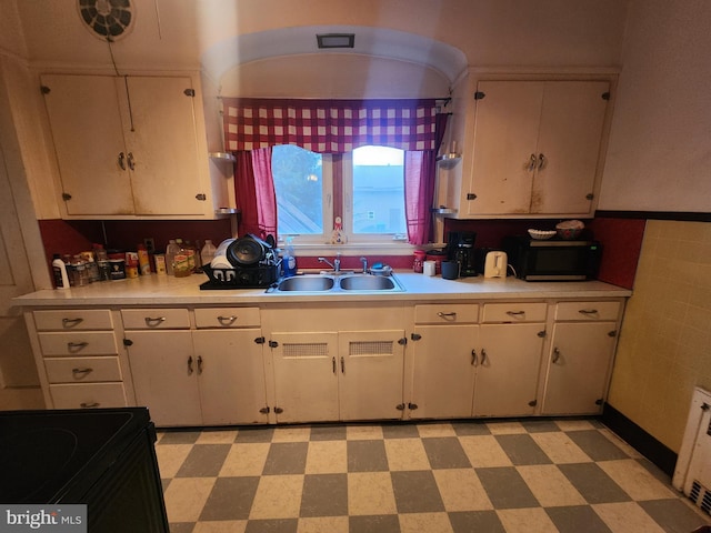 kitchen featuring white cabinetry, sink, and black appliances