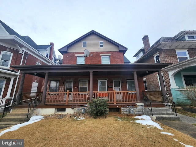 view of front of house featuring covered porch and a front lawn