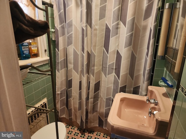 bathroom featuring tile walls, sink, toilet, and a shower with shower curtain