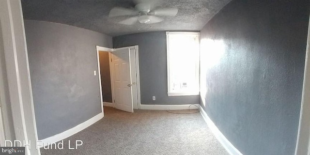 unfurnished bedroom featuring ceiling fan, carpet flooring, and a textured ceiling